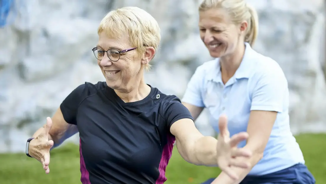 Eine Medical Park Mitarbeiterin hilft einer Patientin bei der Ausführung einer Übung in der orthopädischen Reha