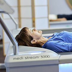 Eine Medical Park Patientin liegt während der physikalischen Therapie auf einer Liege.