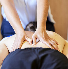 Ein Medical Park Therapeut massiert eine Patientin während einer medizinischen Massagetherapie.