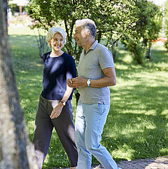 Zwei Medical Park Patienten sind im Park der orthopädischen Reha spazieren.